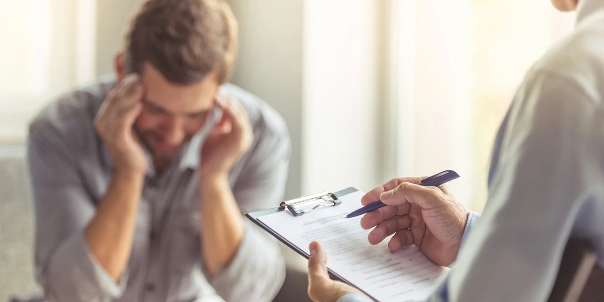 Homem em sessão de psicanálise conversando com o terapeuta, representando o que faz um psicanalista clínico durante o atendimento.