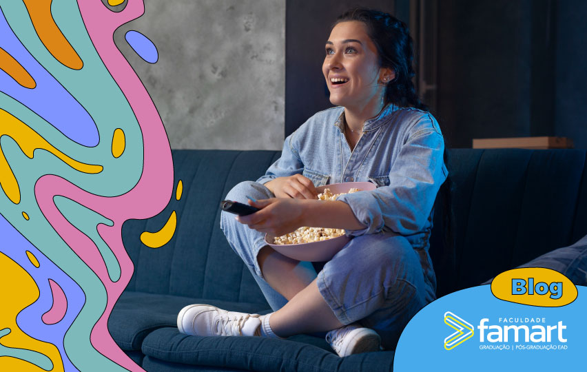 imagem de uma mulher sentada no sofá com balde de pipoca na mão assistindo filme.