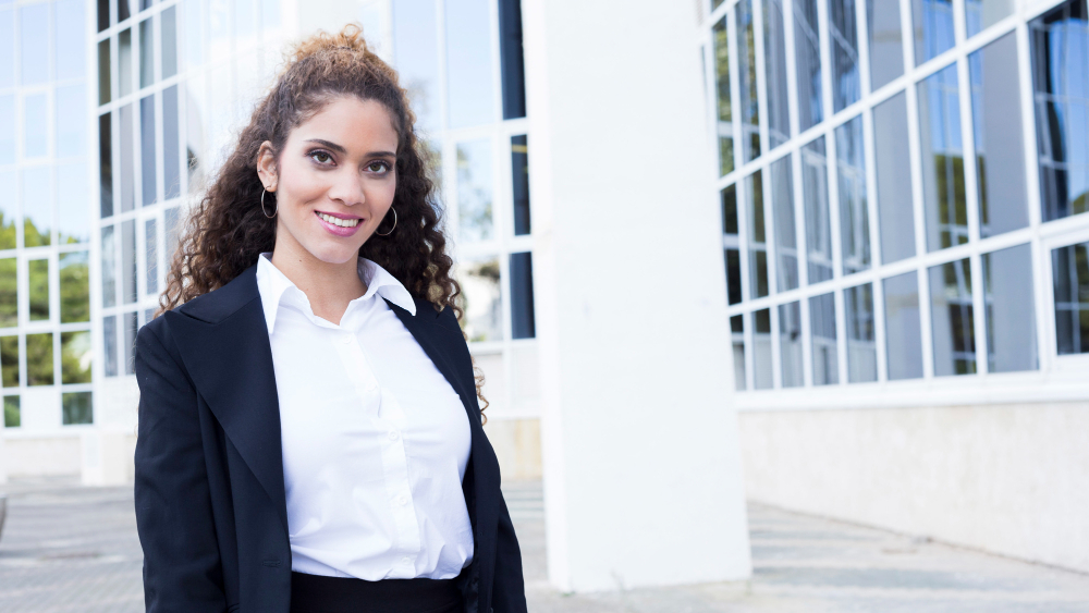 imagem de uma servidora pública em frente a um predio