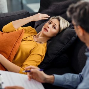 Psicanálise Clínica em prática: paciente no divã atendida por profissional especializado